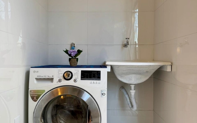 Área de serviço com máquina de lavar e secar no Flat 201 da Ahava Stays em Montes Claros.