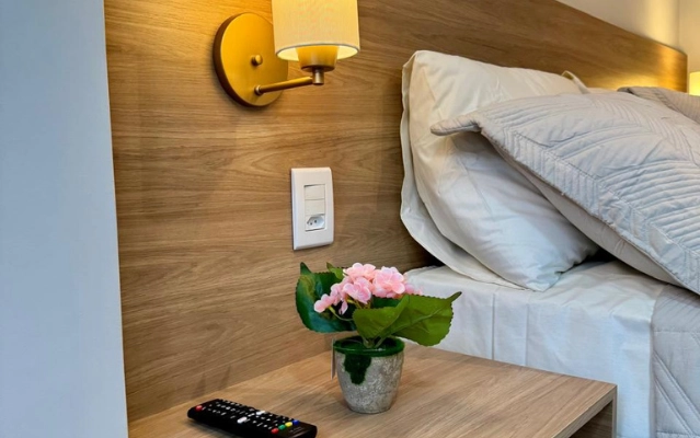 Cama de casal confortável no quarto do Flat 201 da Ahava Stays em Montes Claros MG.