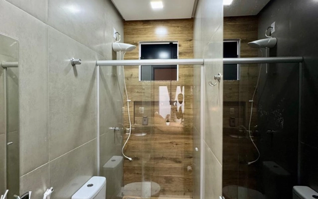 Banheiro moderno com box de vidro no Flat 201 da Ahava Stays em Montes Claros MG.