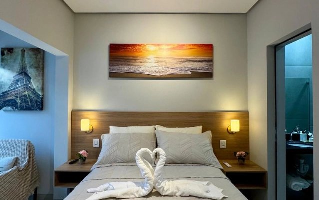 Quarto com cama de casal e banheiro privativo no Flat 201 da Ahava Stays em Montes Claros MG.